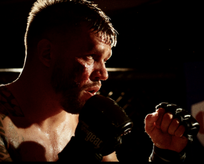 Martin Christophersen i MMA-handsker, set i profil med hænderne oppe
